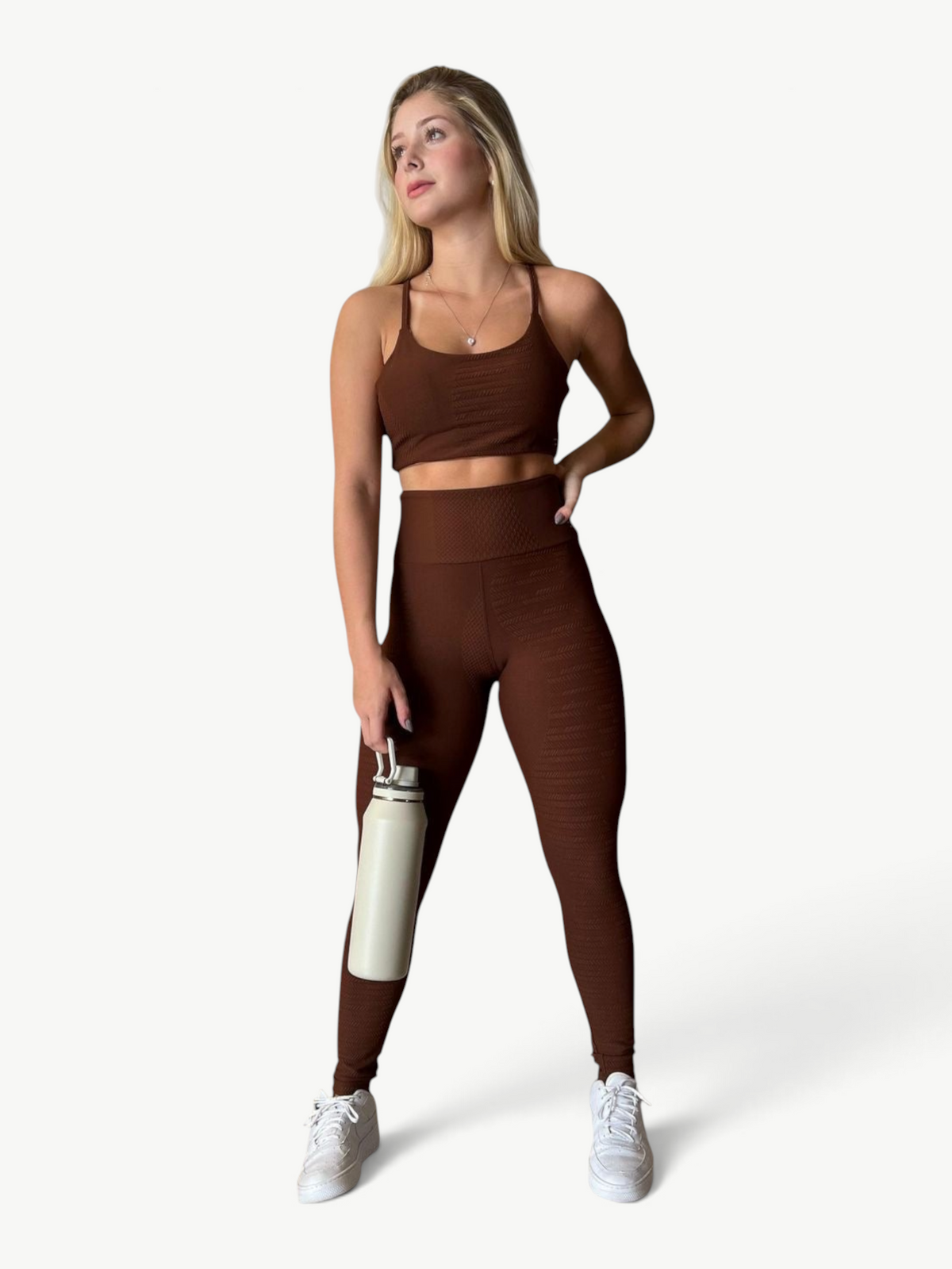 Model wearing JM Brazilian Activewear brown textured crop top and high-waisted leggings set with white sneakers