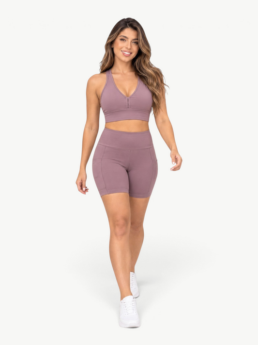 JM Brazilian Activewear mauve high-waisted biker shorts with side pockets worn by a smiling woman in a studio