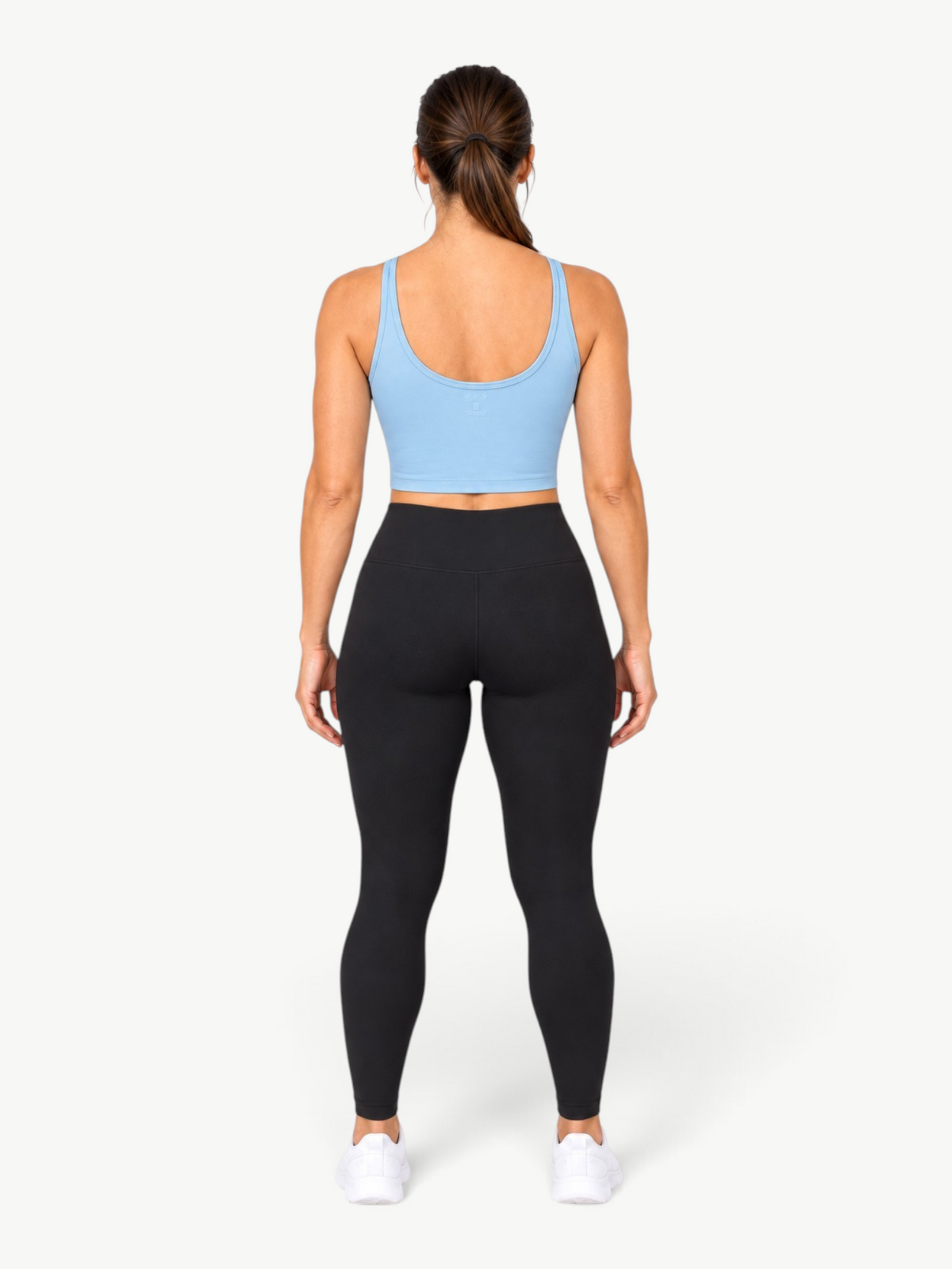 Model wearing JM Brazilian Activewear light blue Dallas crop top with black leggings from behind