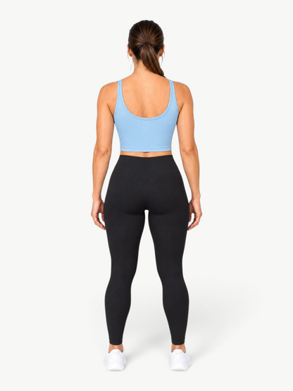 Model wearing JM Brazilian Activewear light blue Dallas crop top with black leggings from behind