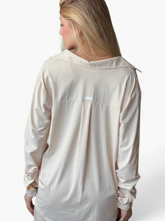 Woman wearing a beige JM Brazilian Activewear long sleeve button-up top with a back yoke and collar detail