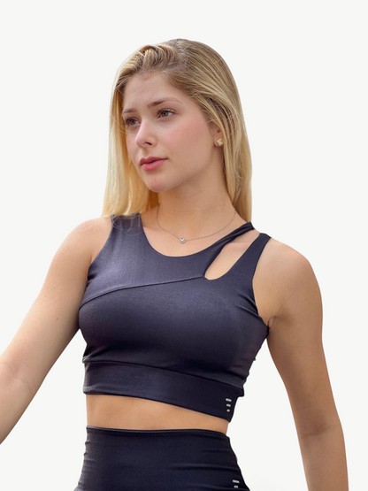 JM Brazilian Activewear Hadassa black crop top with asymmetrical cutout detail worn by a blonde model