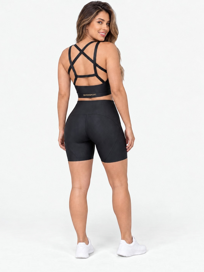 JM Brazilian Activewear black crossback crop top and high-waisted biker shorts set worn by a woman from behind