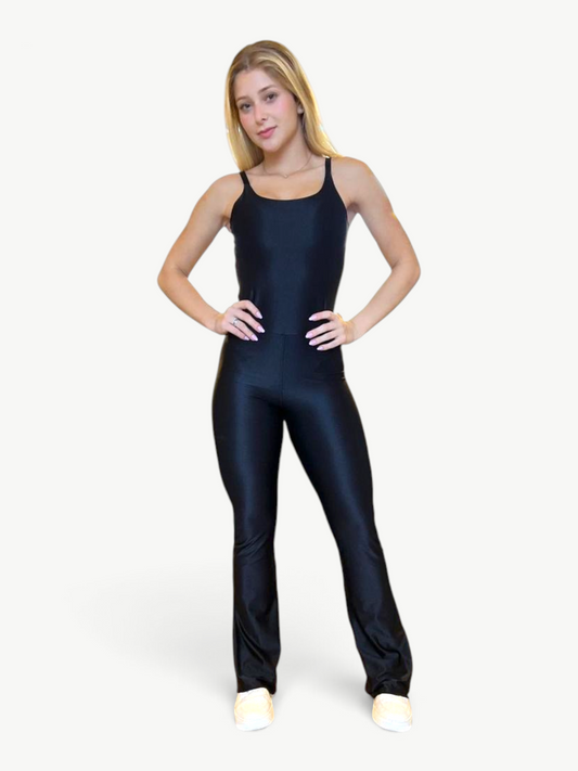 Model wearing a black JM Brazilian Activewear flare jumpsuit with thin straps and a fitted silhouette