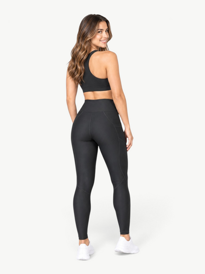 Model wearing JM Brazilian Activewear black high-rise sculpting leggings with side pockets and contour seam details.