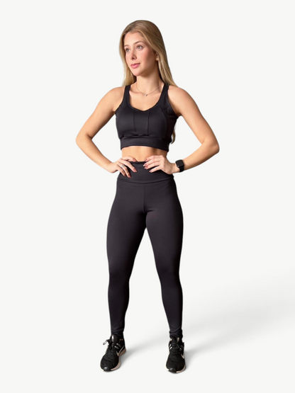 Model wearing JM Brazilian Activewear black high-waisted sculpting leggings and matching sports bra
