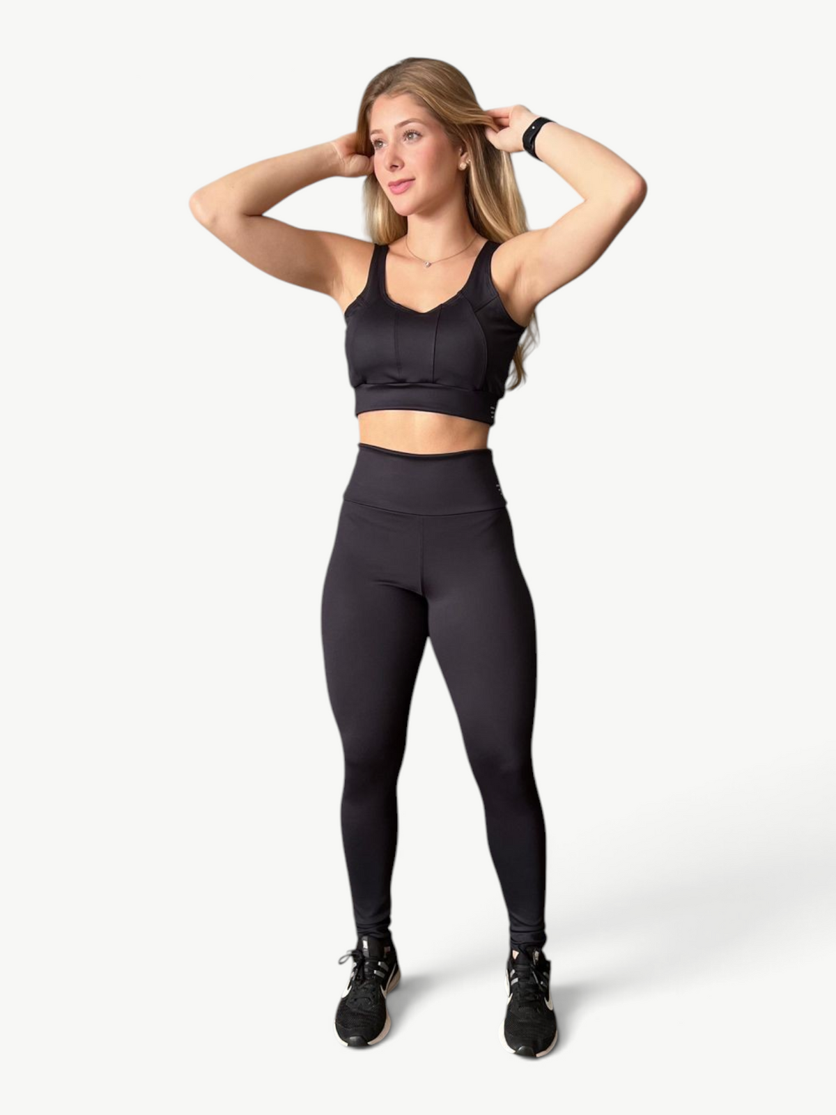 Woman wearing JM Brazilian Activewear black high-waisted sculpting leggings and matching sports bra for workouts.