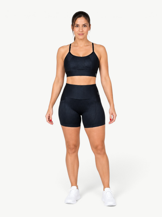 JM Brazilian Activewear black textured two-piece set with high-waisted shorts and a supportive sports bra on a model.