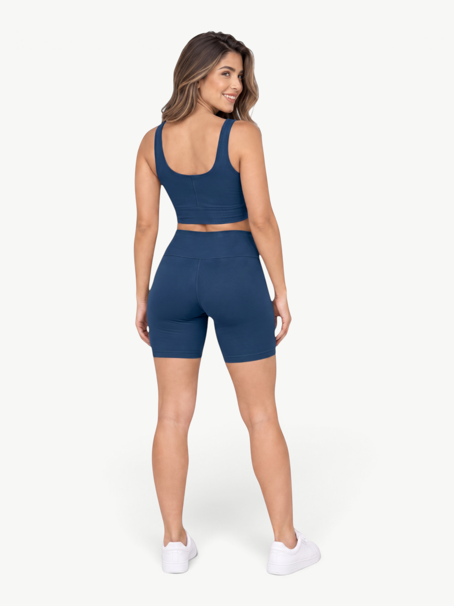 Model wearing JM Brazilian Activewear blue Sculpt Biker Short Set with a cropped tank and high-waisted shorts, back view