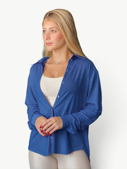 Model wearing a JM Brazilian Activewear blue long sleeve button-up top over a white tank top
