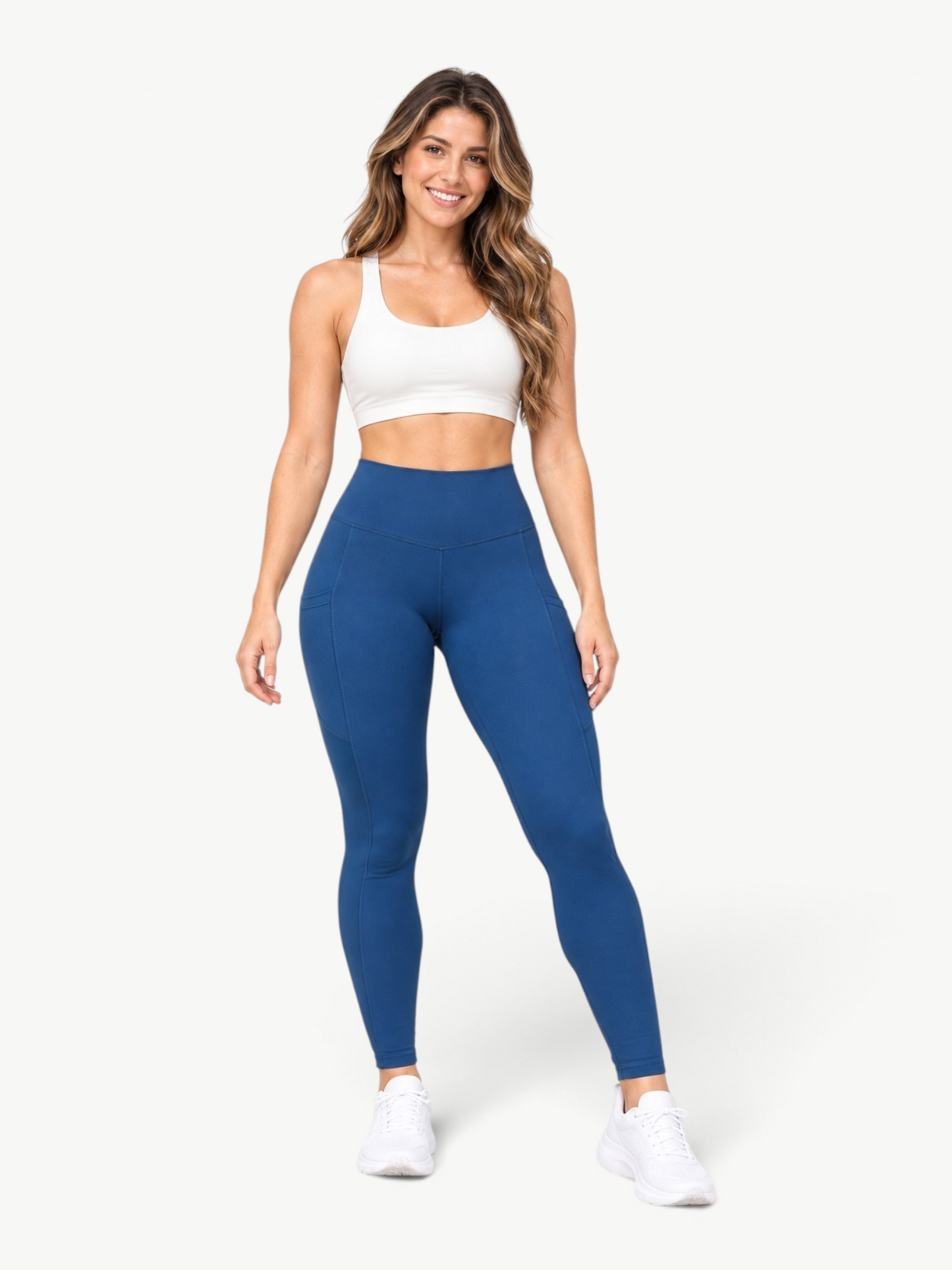 Model wearing JM Brazilian Activewear blue high-rise leggings with side pockets and smooth, bleach-resistant fabric.