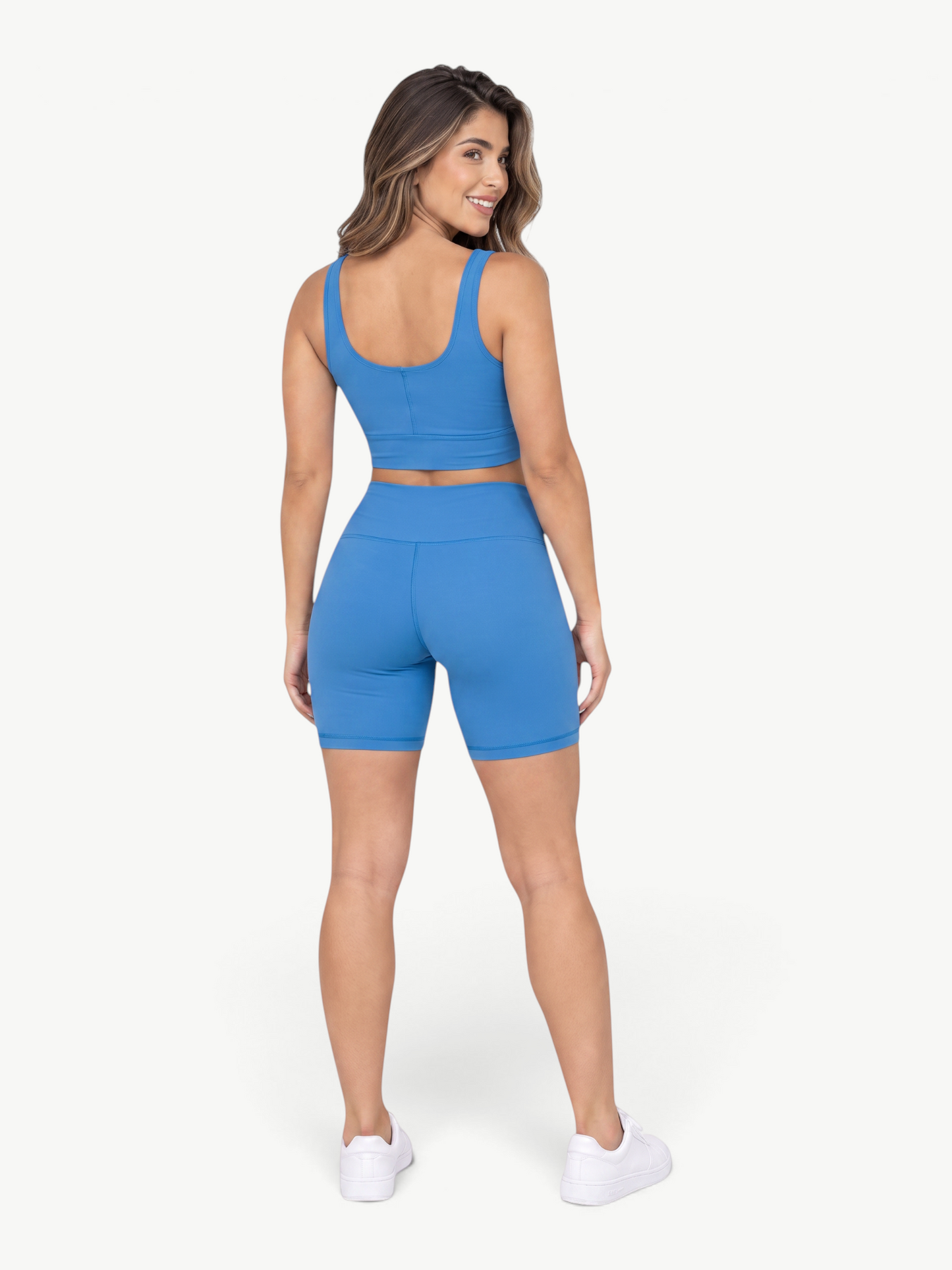 Model wearing JM Brazilian Activewear blue Sculpt Biker Short Set with a cropped tank and high-waisted shorts, back view