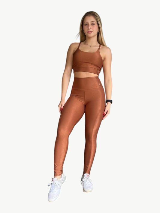 Model wearing a JM Brazilian Activewear bronze ribbed high-waisted legging set with a matching sports bra.