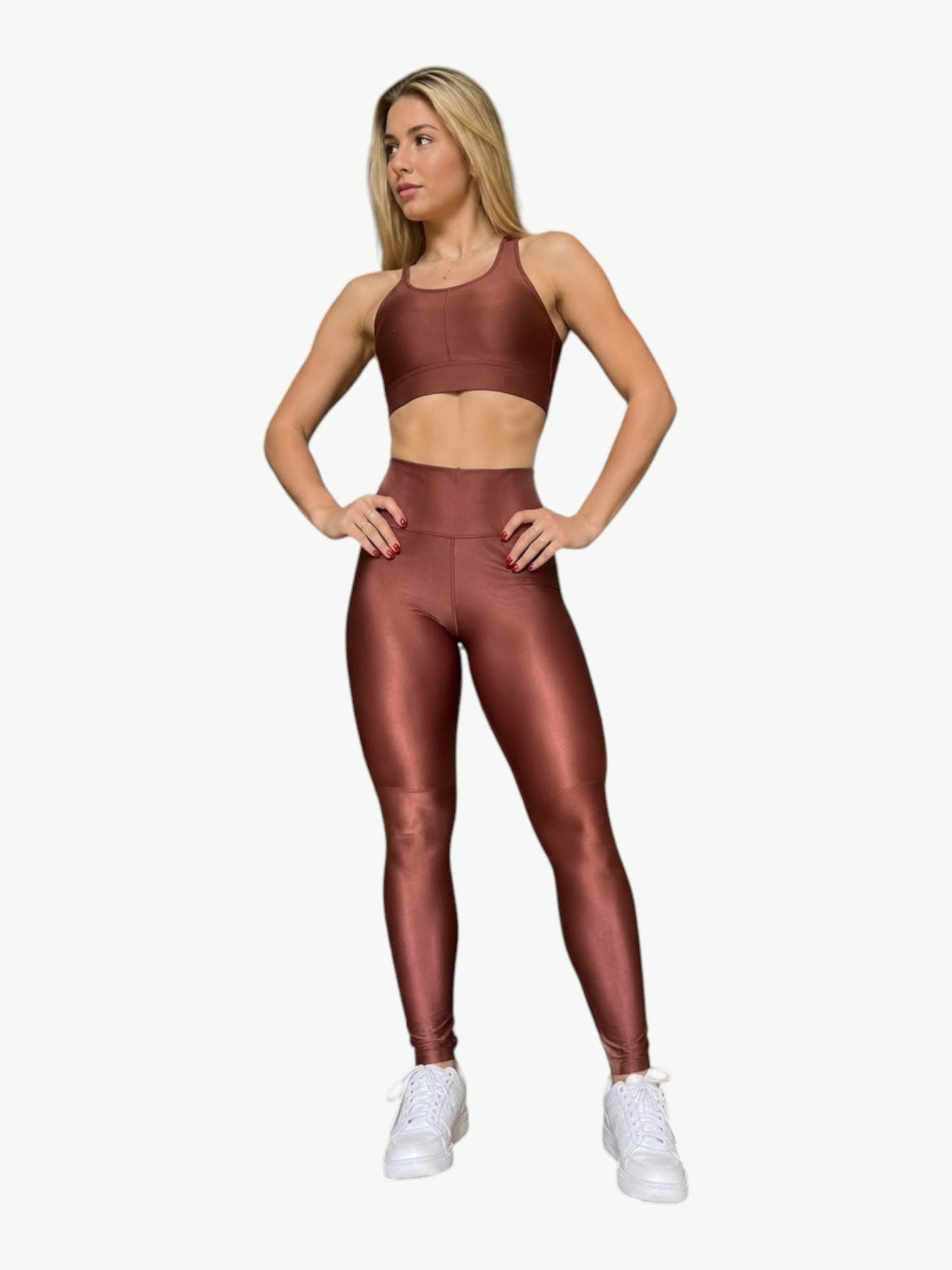 Model wearing a metallic bronze JM Brazilian Activewear sculpting crossback top and high-waisted leggings set.