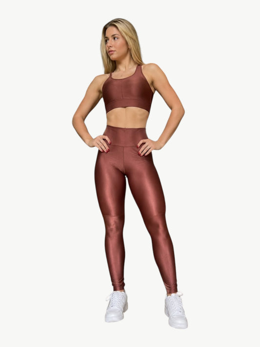 Model wearing a metallic bronze JM Brazilian Activewear sculpting crossback top and high-waisted leggings set.