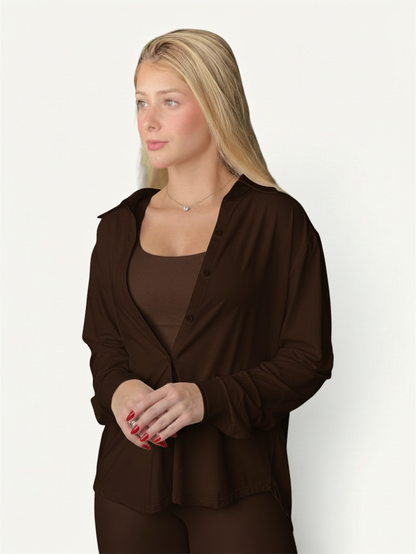 Blonde model wearing a dark brown JM Brazilian Activewear long sleeve button-up top over a matching ribbed tank top.