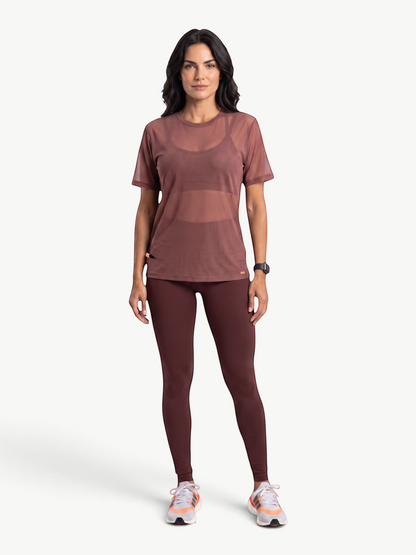Model wearing a JM Brazilian Activewear sheer brown mesh t-shirt over a matching sports bra and leggings
