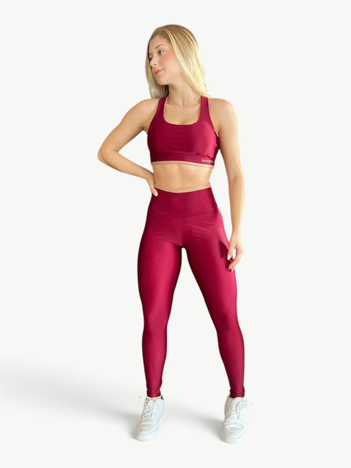 Model wearing a JM Brazilian Activewear burgundy cropped top and high-rise leggings set with contrast detailing.