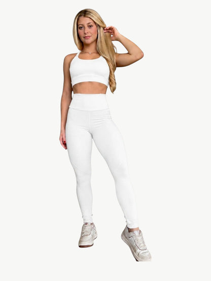 Modelo loira vestindo conjunto de activewear branco JM Brazilian Activewear com top cropped e legging de cintura alta