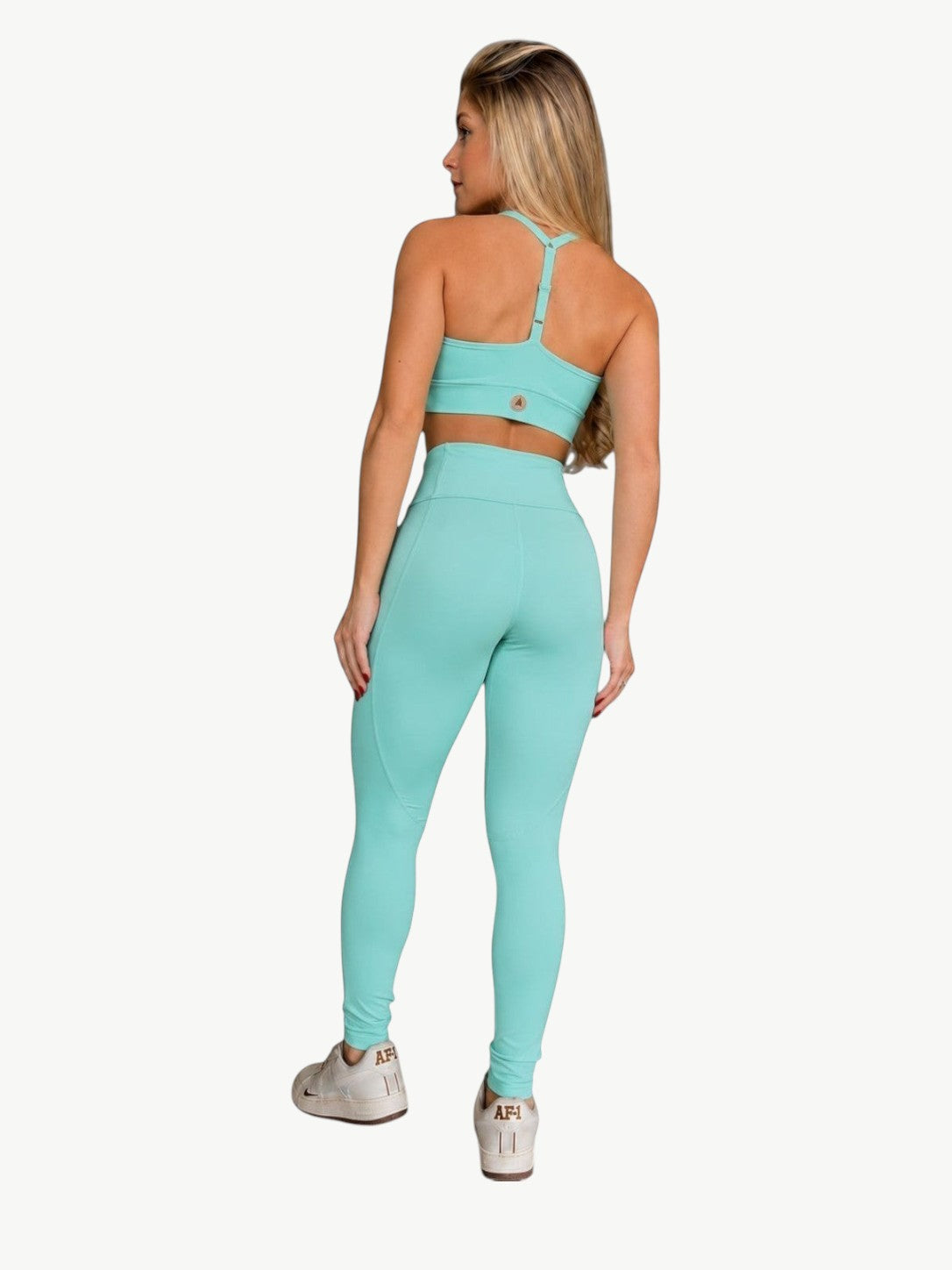 Modelo vestindo conjunto Angel Legging Set da JM Brazilian Activewear, top cropped e legging cintura alta verde água.