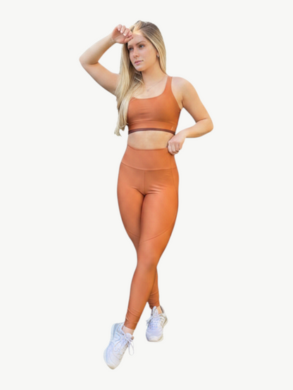 JM Brazilian Activewear copper cross-back sports bra and high-waisted leggings set worn by a blonde model