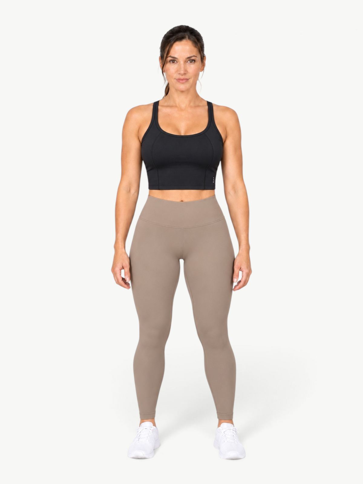 Model wearing a black JM Brazilian Activewear Dallas crop top with taupe leggings and white sneakers