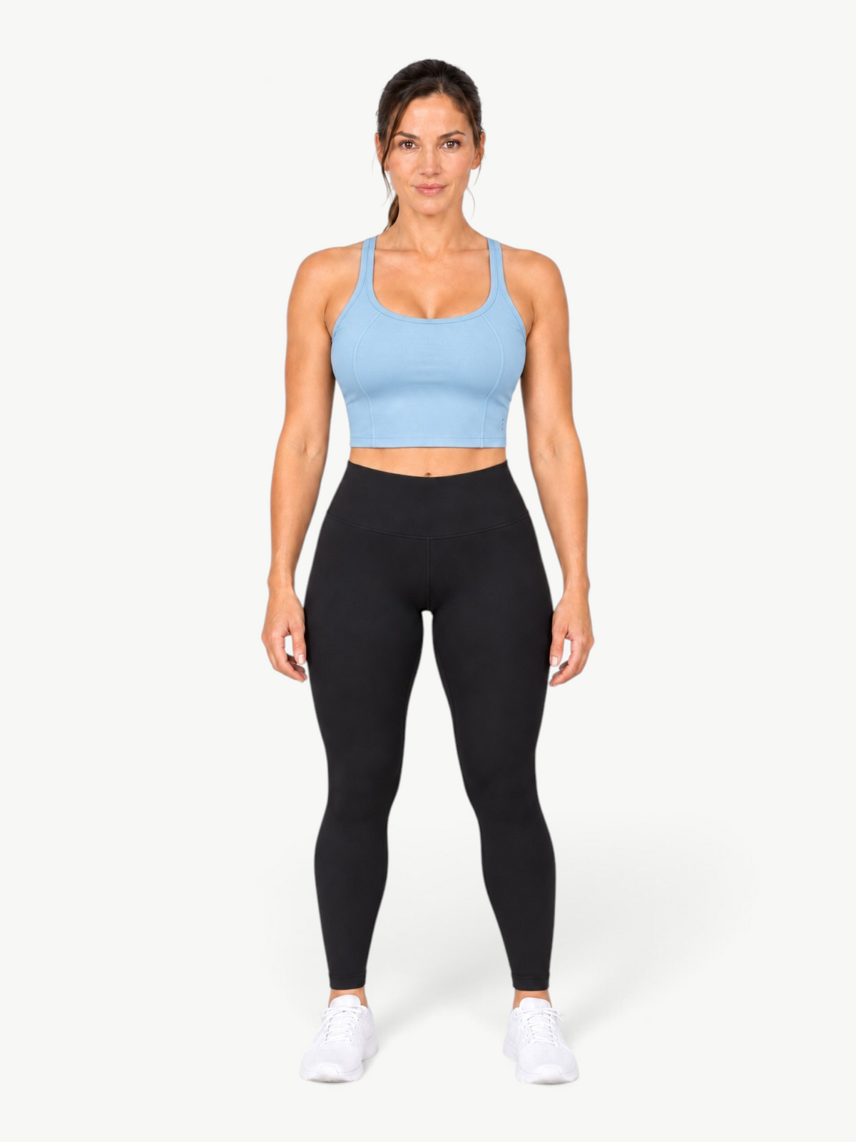 Model wearing JM Brazilian Activewear light blue Dallas crop top with black leggings and white sneakers