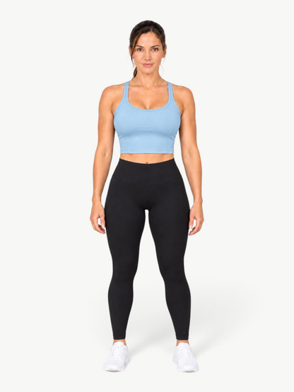 Model wearing JM Brazilian Activewear light blue Dallas crop top with black leggings and white sneakers