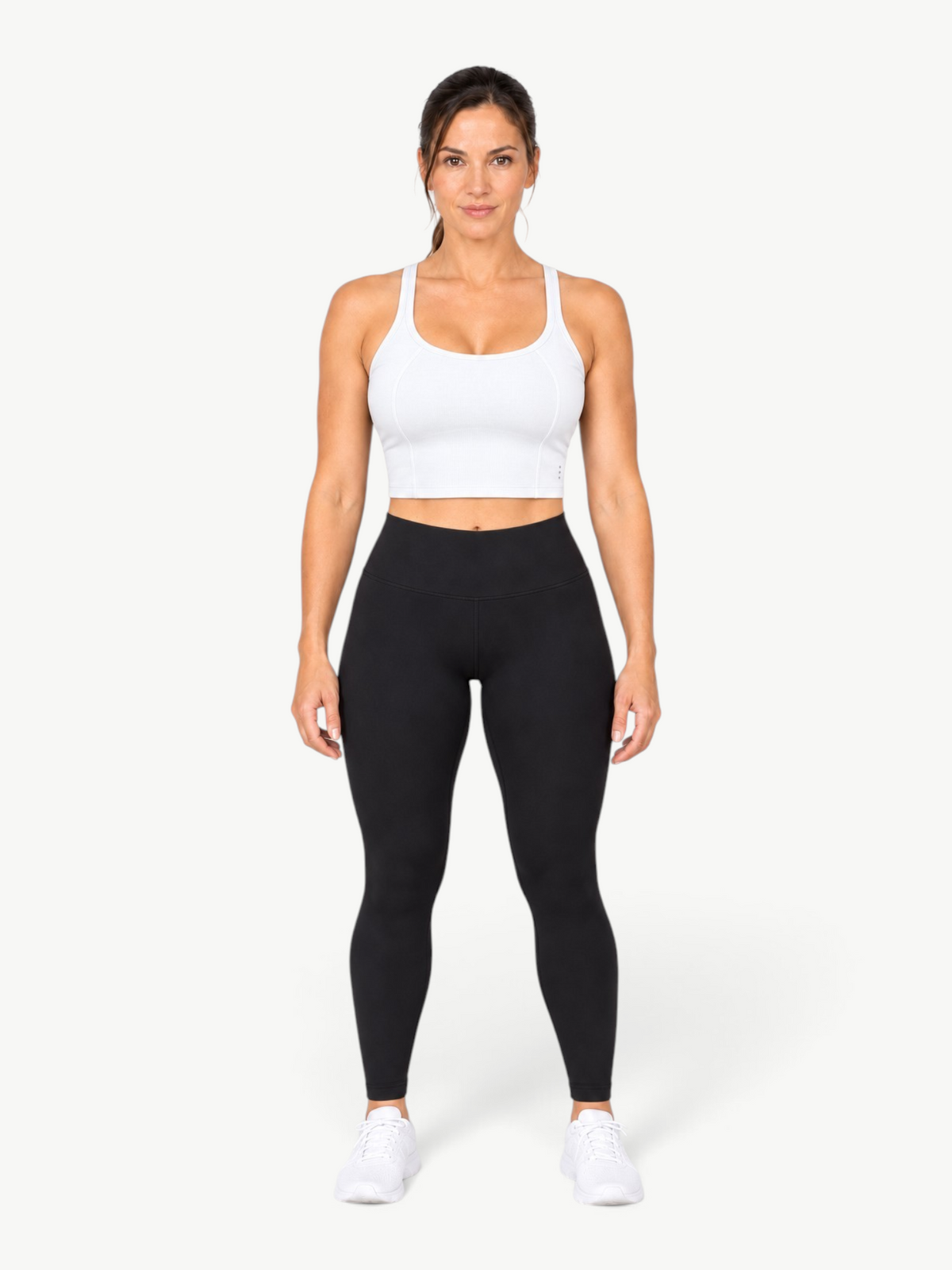 Model wearing a white JM Brazilian Activewear Dallas crop top with black leggings and white sneakers