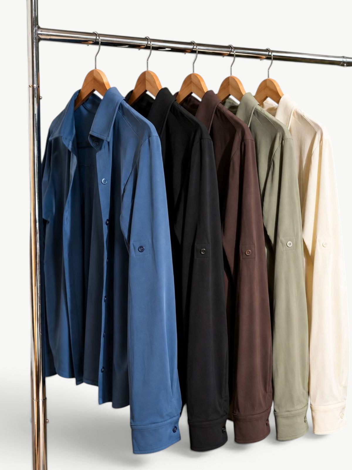 JM Brazilian Activewear long sleeve button-up tops in blue, black, brown, olive, and cream on a clothing rack