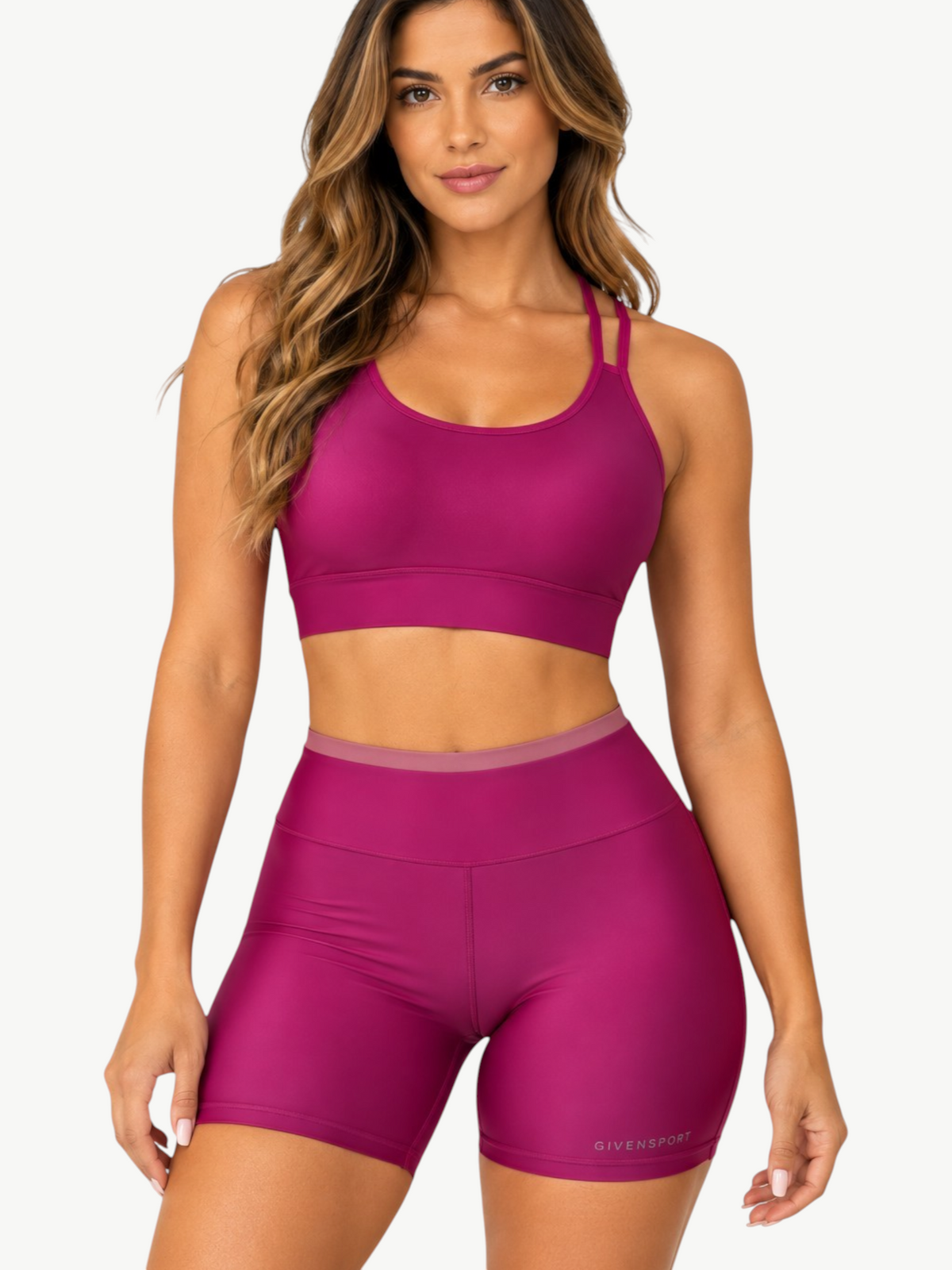 Model wearing JM Brazilian Activewear magenta two-piece crop top and high-waisted shorts set in soft stretchy fabric