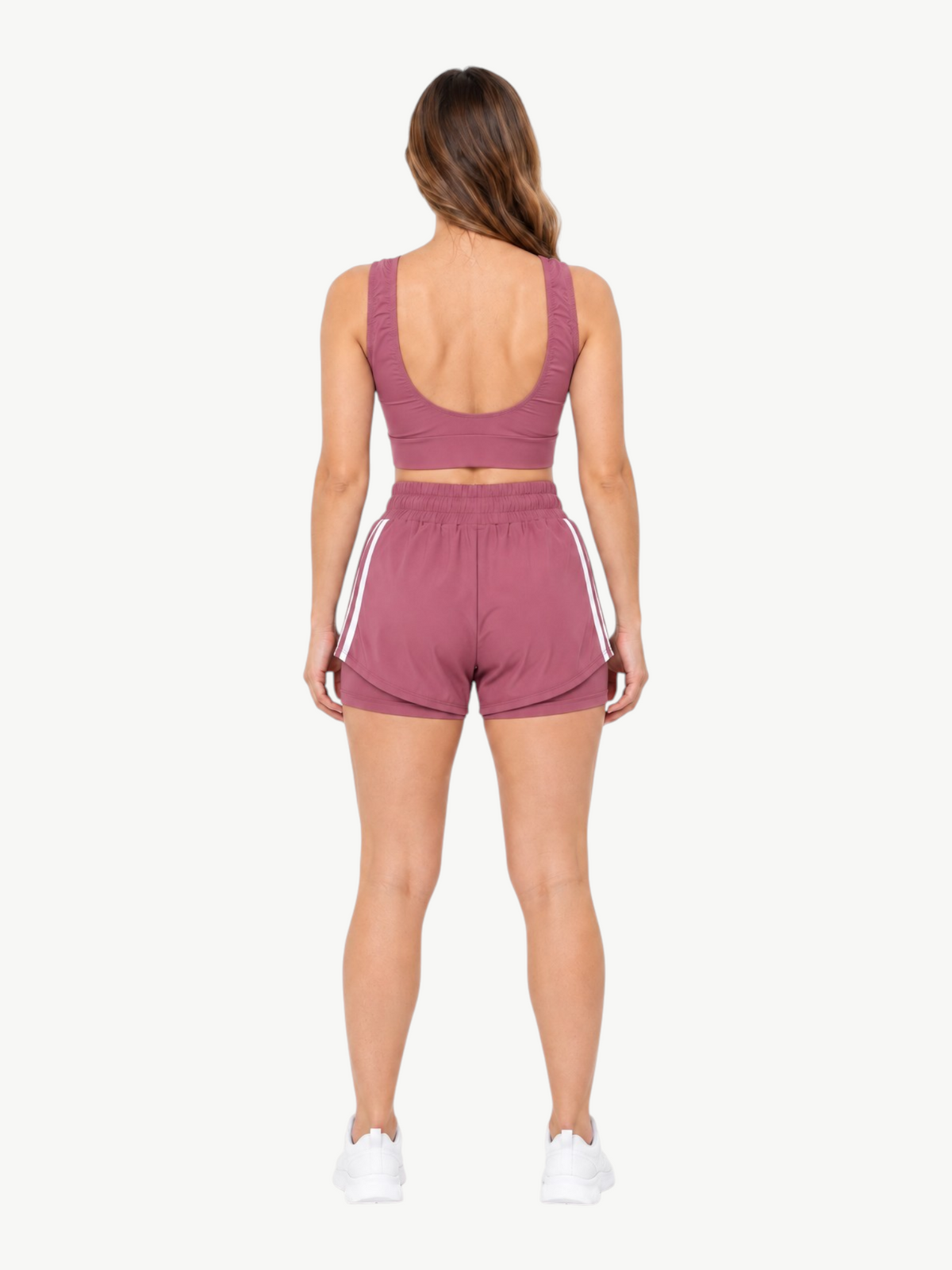 Back view of a woman wearing a mauve JM Brazilian Activewear 2-in-1 short set with a crop top and layered shorts.