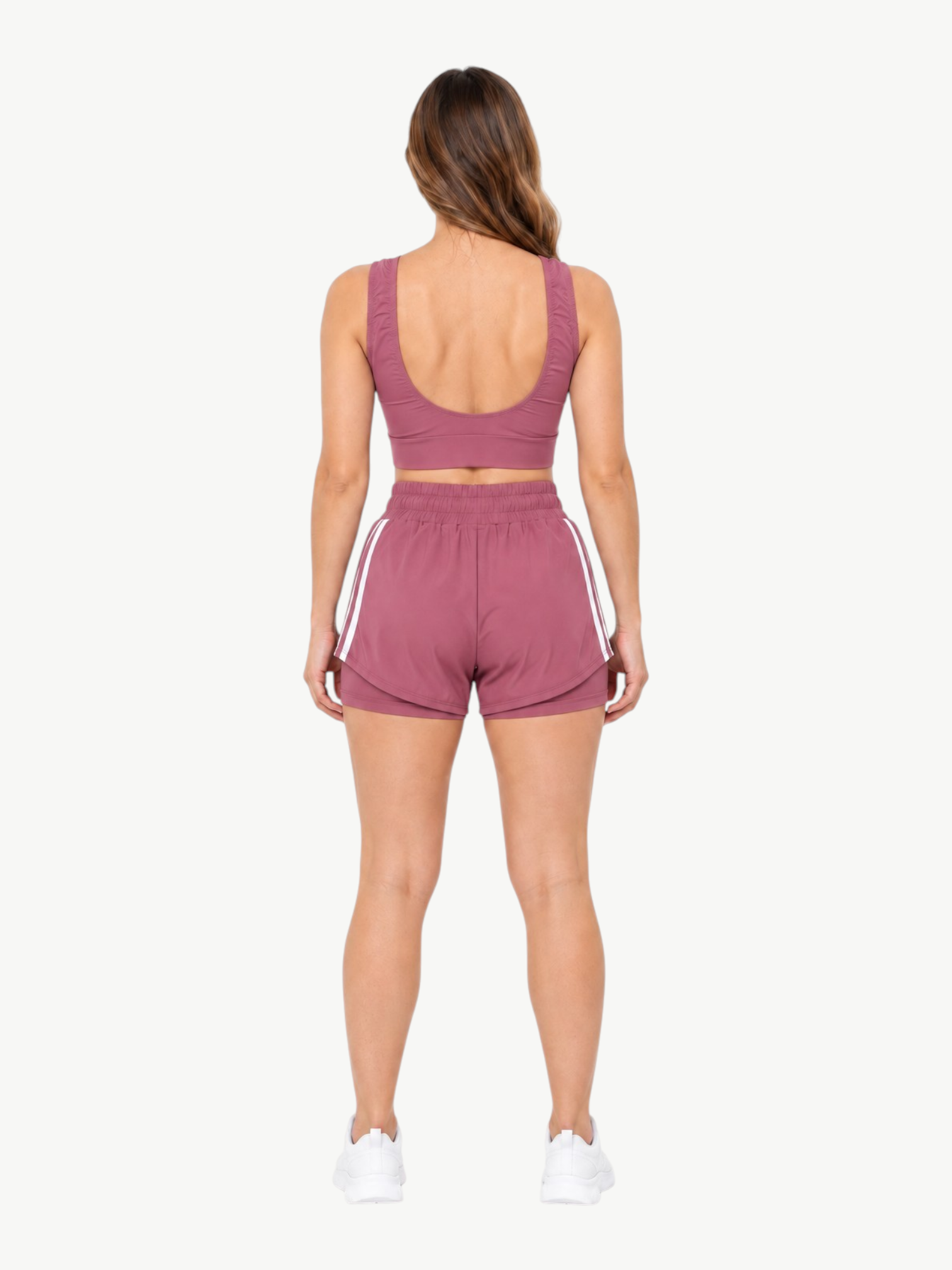 Back view of a woman wearing a mauve JM Brazilian Activewear 2-in-1 short set with a crop top and layered shorts.