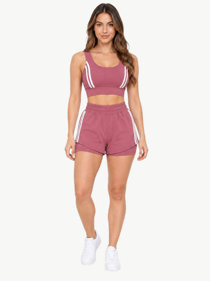 Model wearing a mauve JM Brazilian Activewear 2-in-1 short set with a supportive crop top and layered athletic shorts.