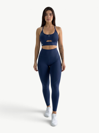 Model wearing JM Brazilian Activewear navy blue matching set with a supportive cutout top and high-waisted leggings.