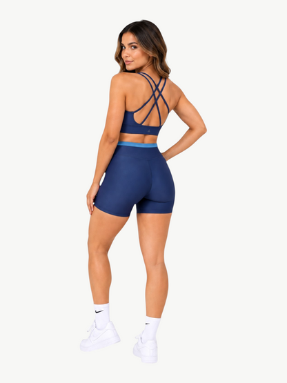Model wearing JM Brazilian Activewear navy blue Aurora short set with a strappy crop top and high-waisted shorts
