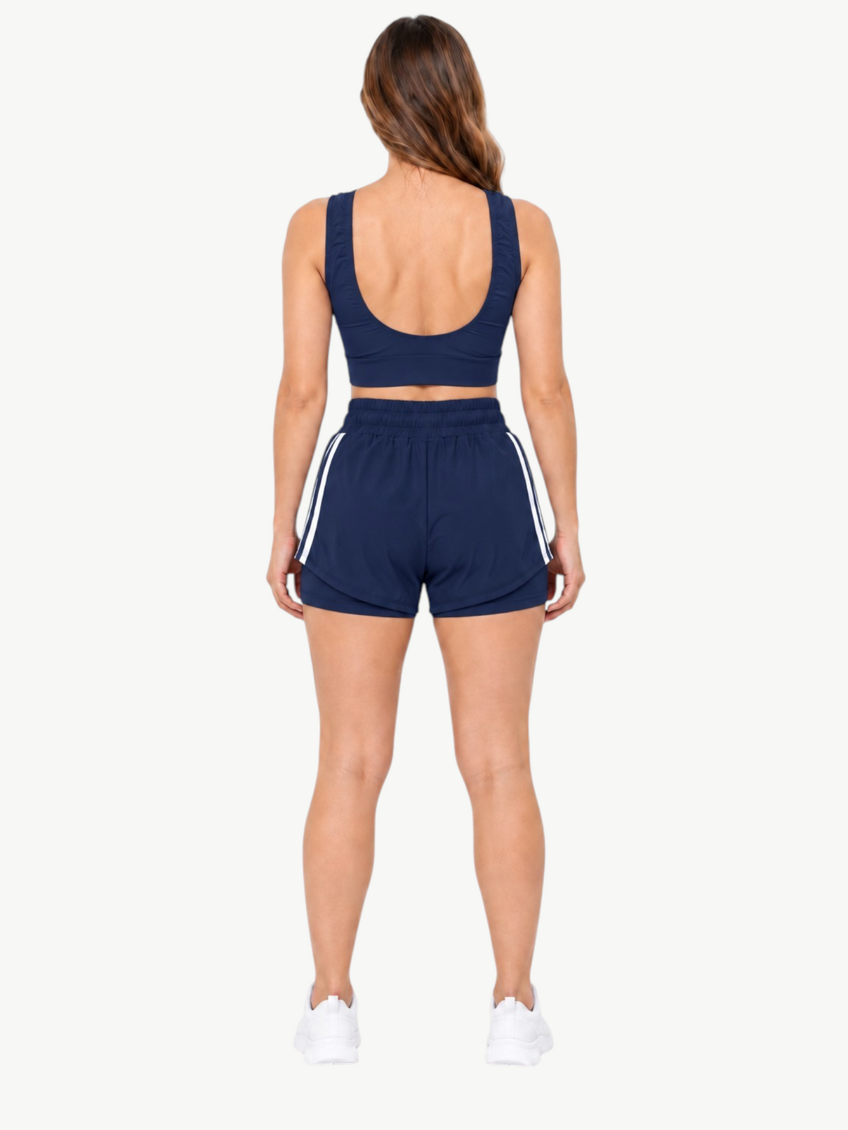 Woman wearing JM Brazilian Activewear navy blue 2-in-1 short set with crop top and layered shorts, back view
