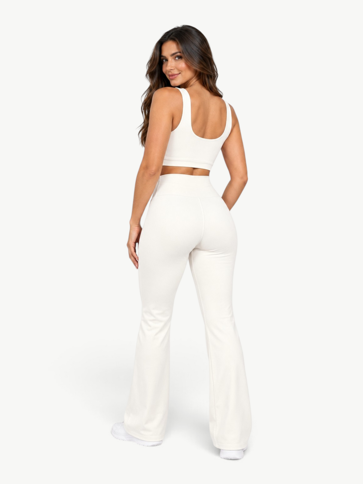 Model wearing JM Brazilian Activewear off-white two-piece set with cropped top and high-waisted flare leggings