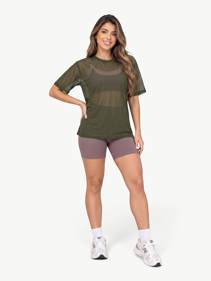 Model wearing a JM Brazilian Activewear olive green sheer mesh t-shirt over a sports bra with mauve athletic shorts.