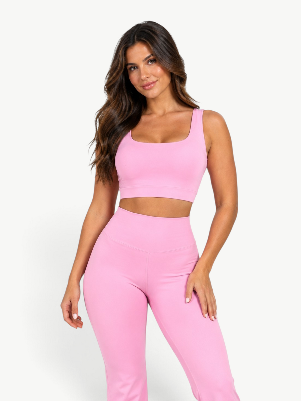 Model wearing JM Brazilian Activewear pink Contour Flare Set with a supportive cropped top and high-waisted leggings.