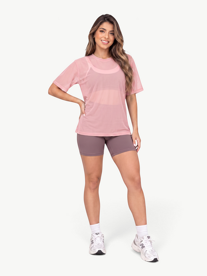 Model wearing a JM Brazilian Activewear pink sheer mesh t-shirt with a relaxed fit over a matching sports bra