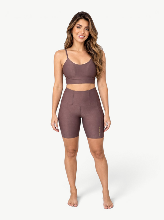 Model wearing JM Brazilian Activewear brown ribbed two-piece set with scoop-neck crop top and high-waisted biker shorts