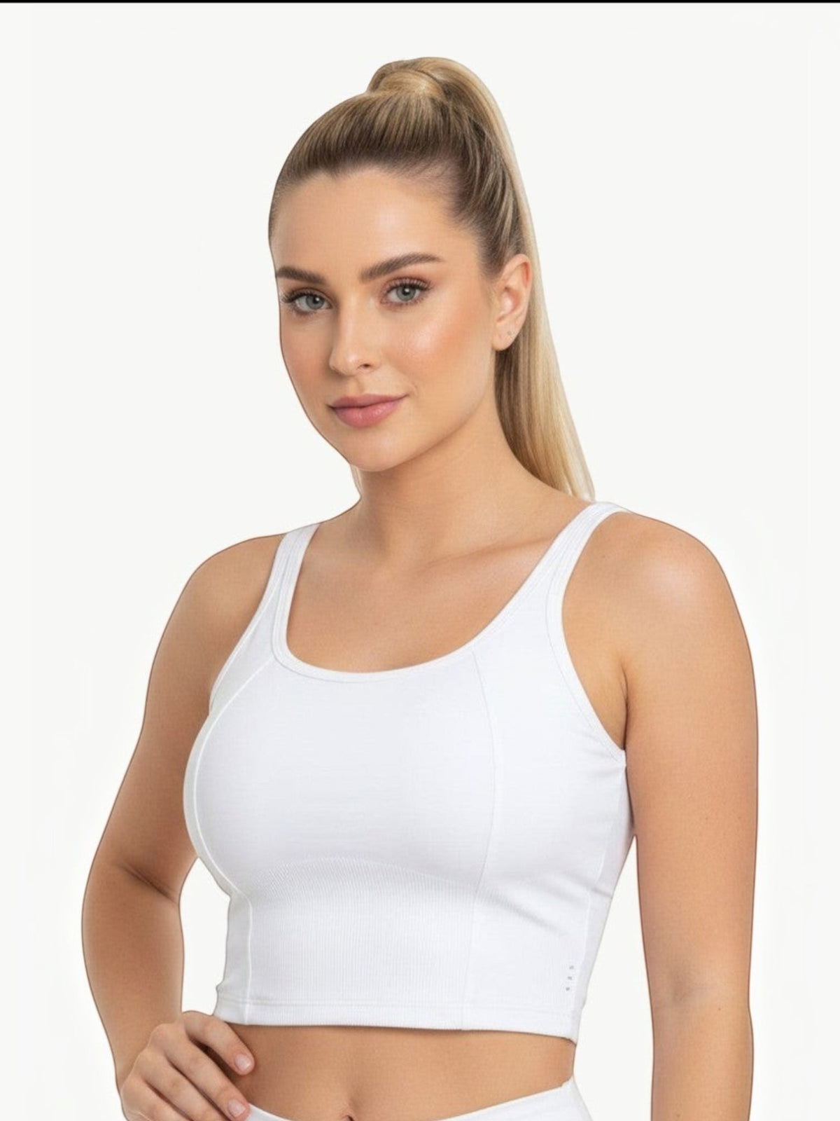 Modelo vestindo o top cropped branco Dallas da JM Brazilian Activewear, feito em tecido elástico confortável.