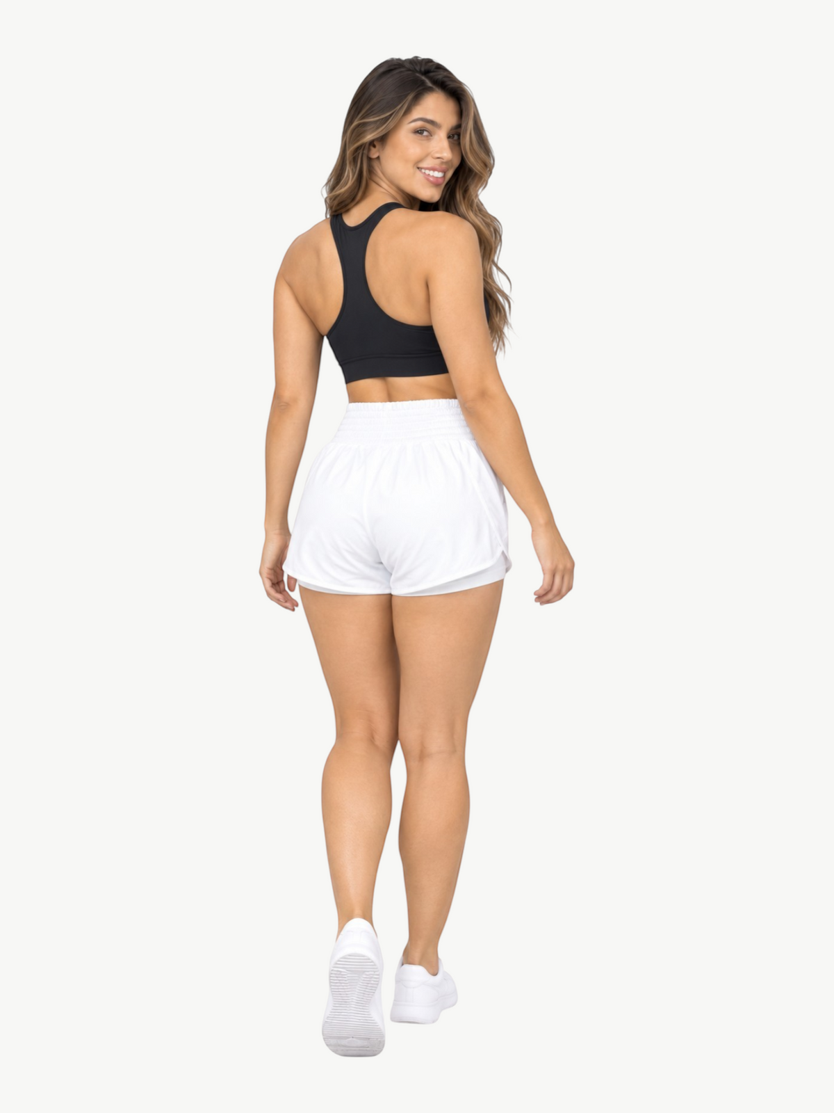 Model wearing JM Brazilian Activewear white 2-in-1 athletic shorts with a high waistband and black sports bra