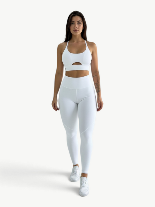 Model wearing a white JM Brazilian Activewear two-piece set with a supportive cutout top and high-waisted leggings.