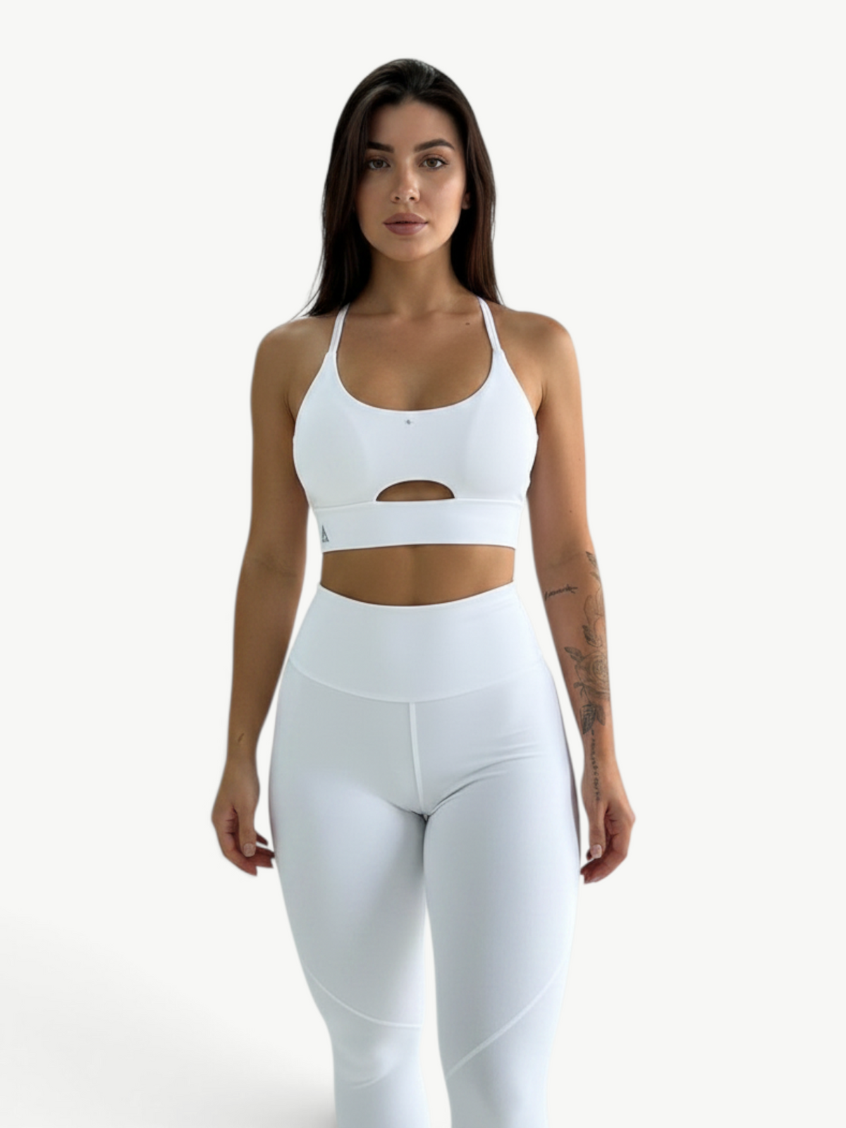 Model wearing a white JM Brazilian Activewear two-piece set with a supportive cutout top and high-waisted leggings.