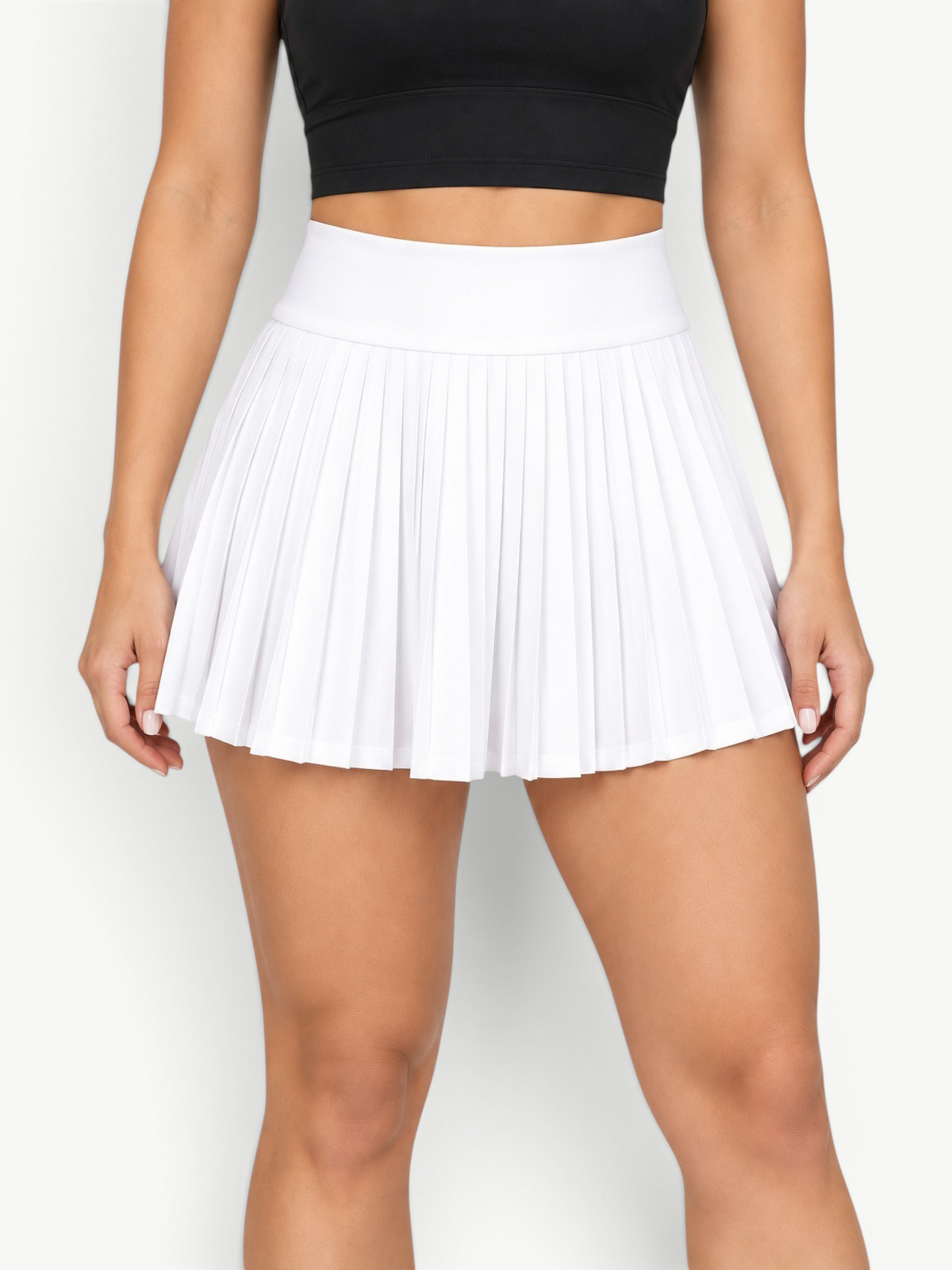 JM Brazilian Activewear white high-waisted pleated athletic skort worn with a black sports bra